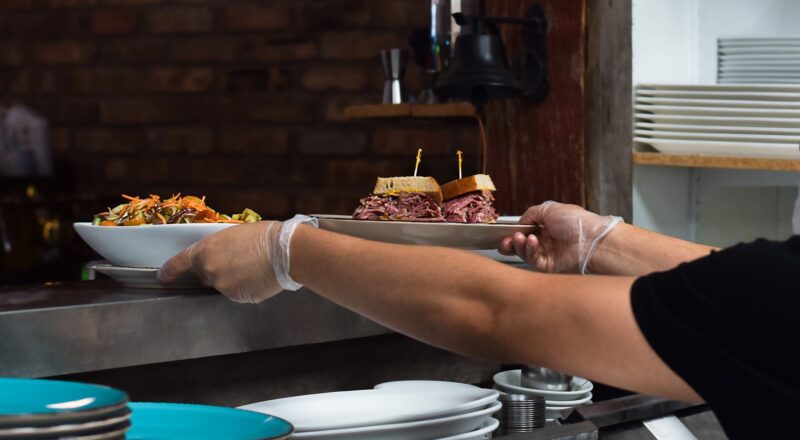 chef serving plated food with gloves